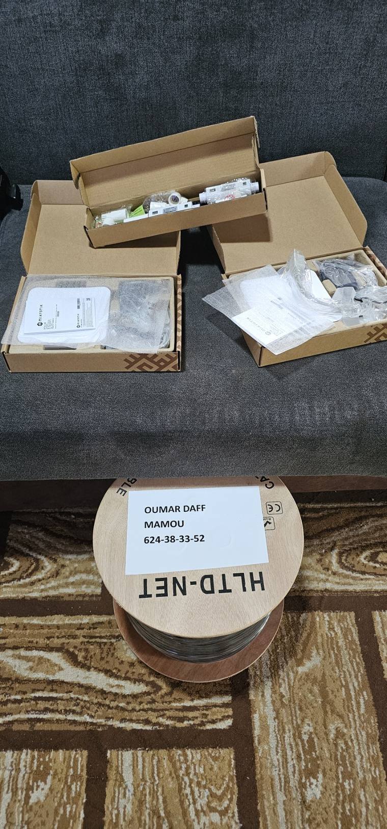 Cartons de matériel Mikrotik et touret de câble réseau prêts pour un chantier